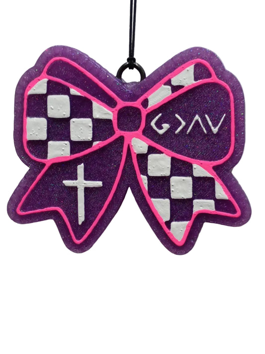 Purple and white checkered bow-shaped car freshener on a purple base with a hot pink outline. The symbols are painted in white on opposite sides of the checkerboard design.