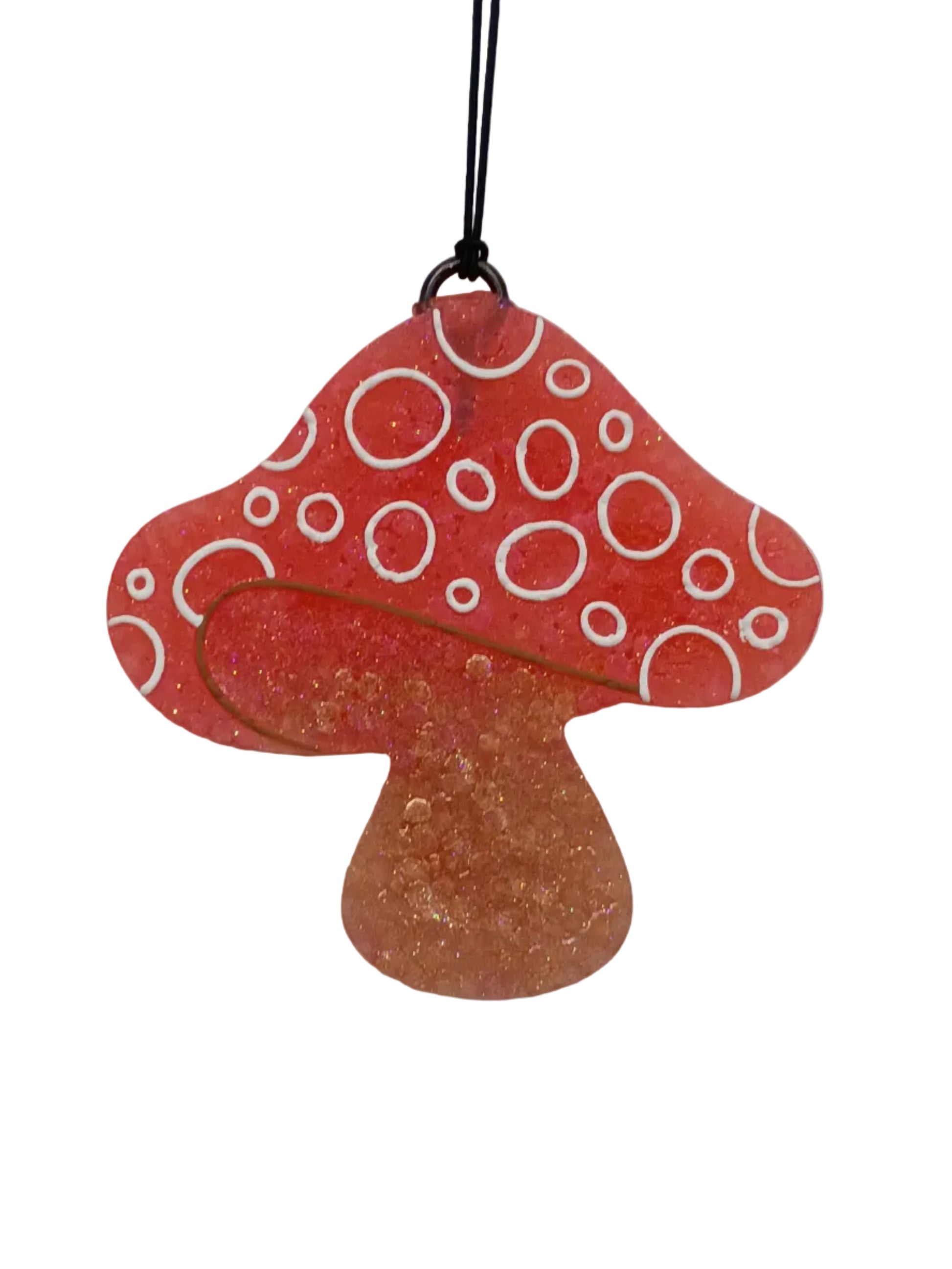 Mushroom shaped car freshener with white circular patterns on a red base at the top and a plain light brown base for the stem. 