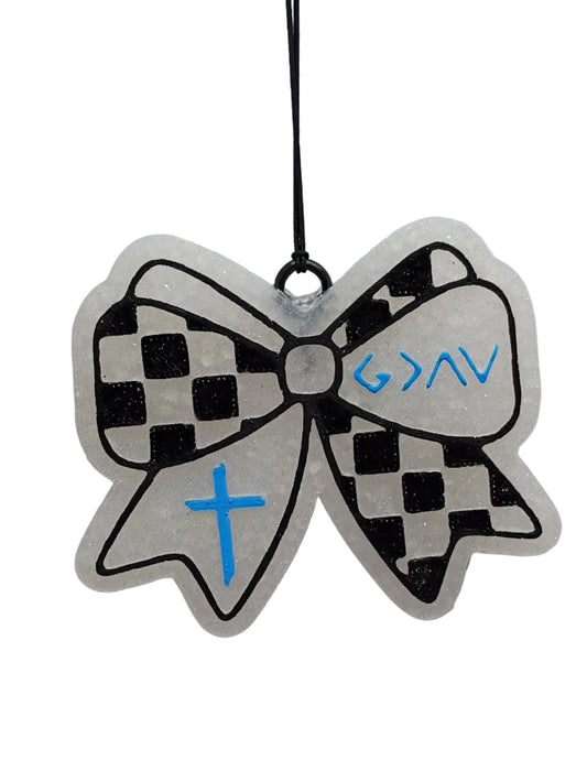 Black and white checkered bow-shaped car freshener on a white base.  The symbols are painted in light blue on opposite sides of the checkerboard design. 