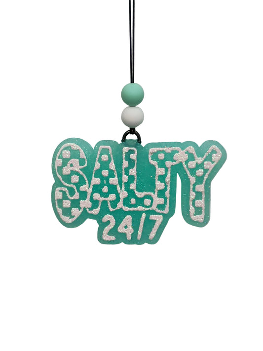 Hanging car air freshener with checkered design lettering that says  'salty 24/7'  in white glitter on a mint green base.  Mint and white beads decorate the elastic hanger. 