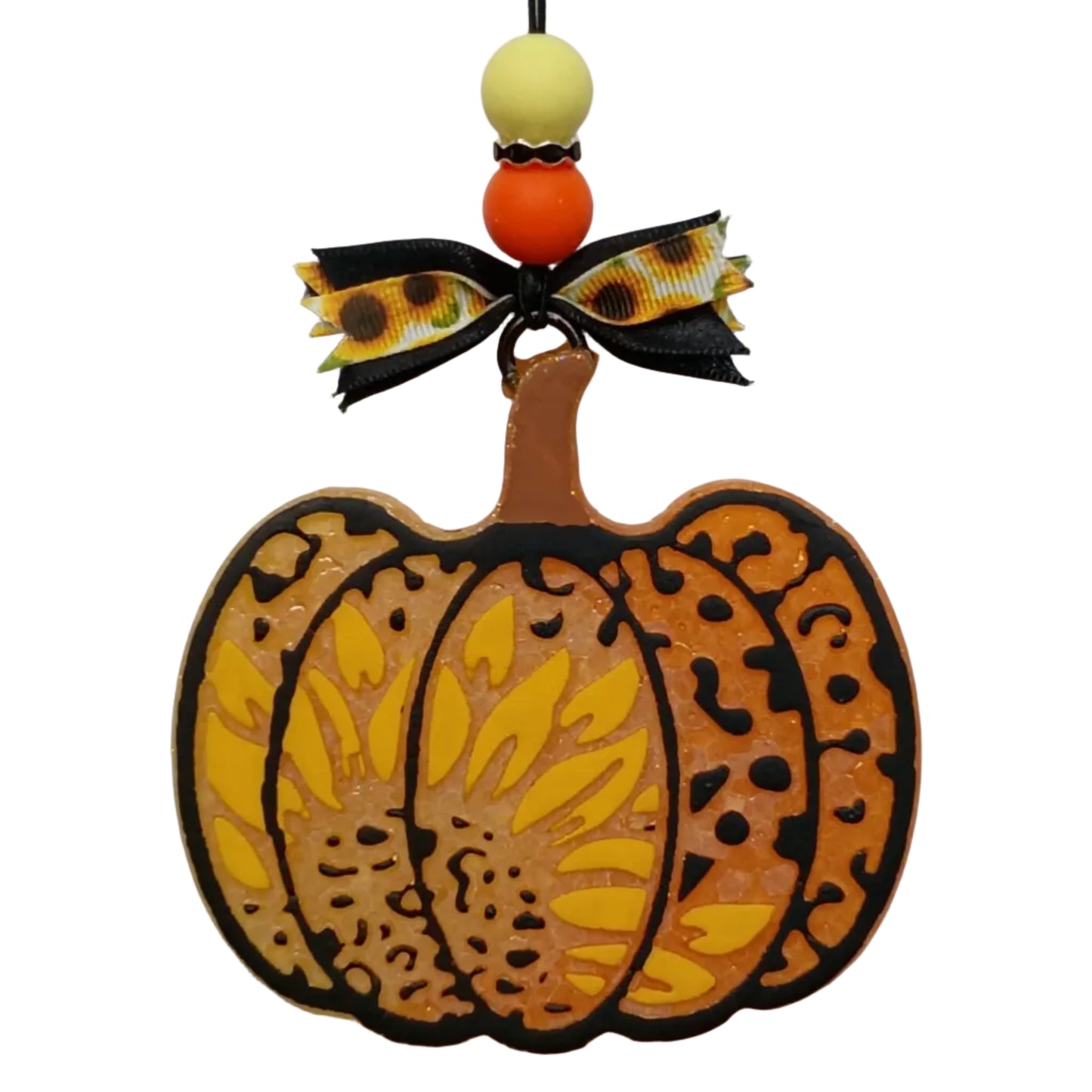 A decorative autumn-themed car freshener  shaped like a pumpkin, featuring a hand-painted yellow sunflower on an orange and yellow ombre base with black outlines and a handpainted black leopard print pattern, attached to a black string with black and sunflower-patterned ribbon and orange and yellow beads.