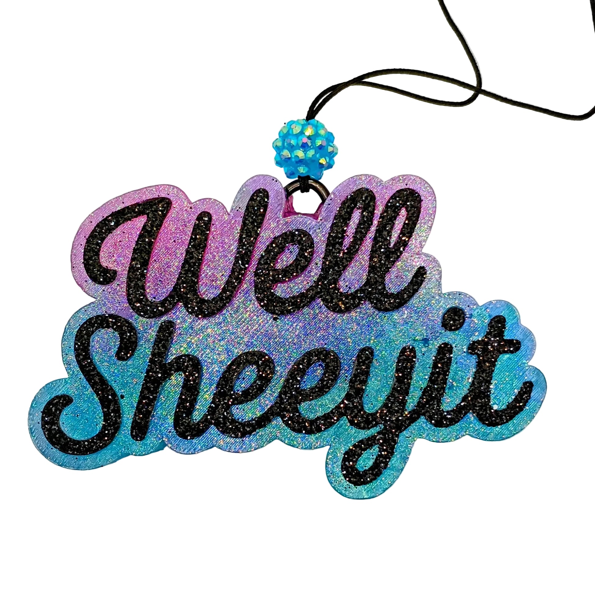  'Well Sheeyit' hanging car air  freshener with a blue and purple ombre base and black glitter lettering. 